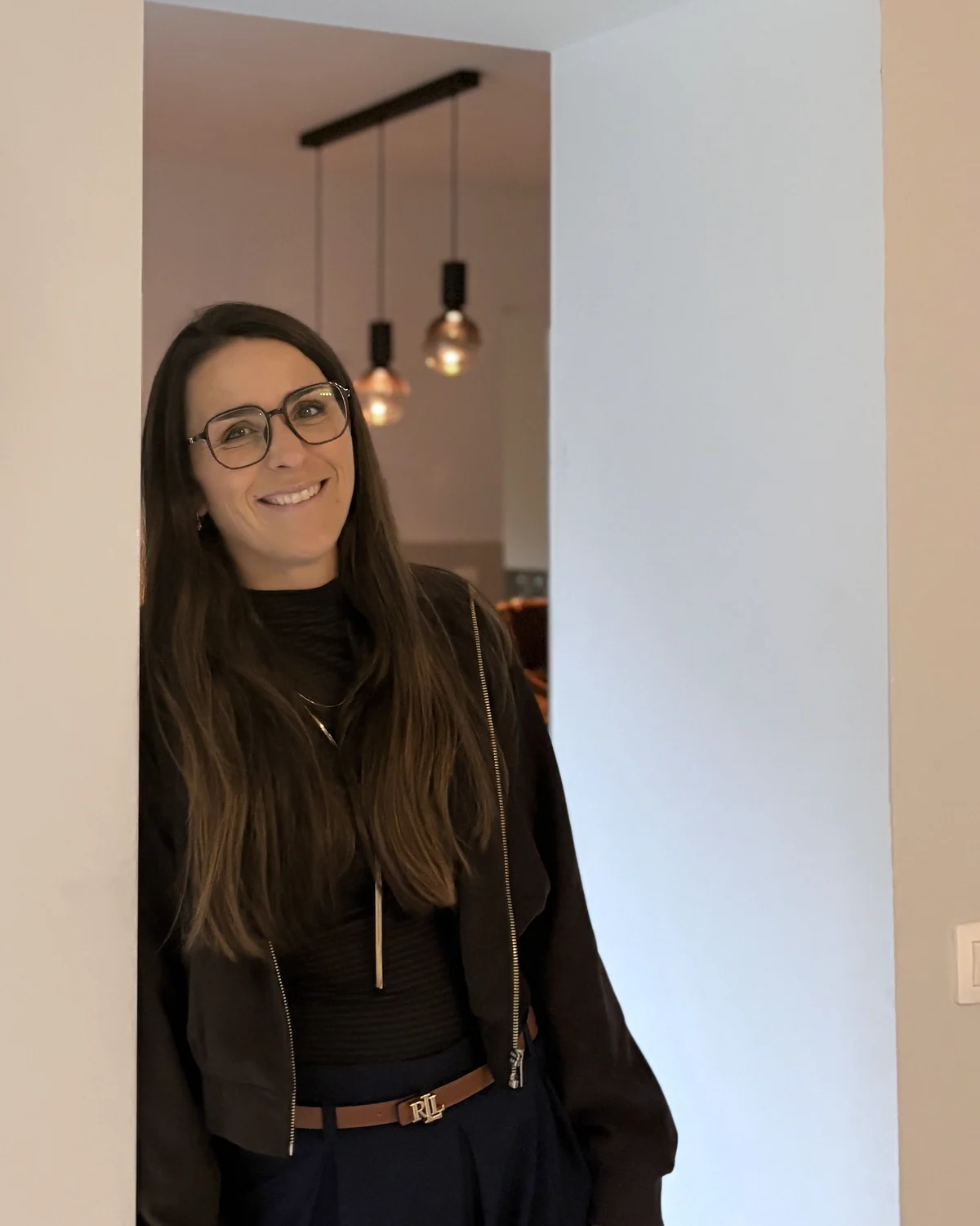 Élise Fosséprez souriante, debout dans l’encadrement d’une porte